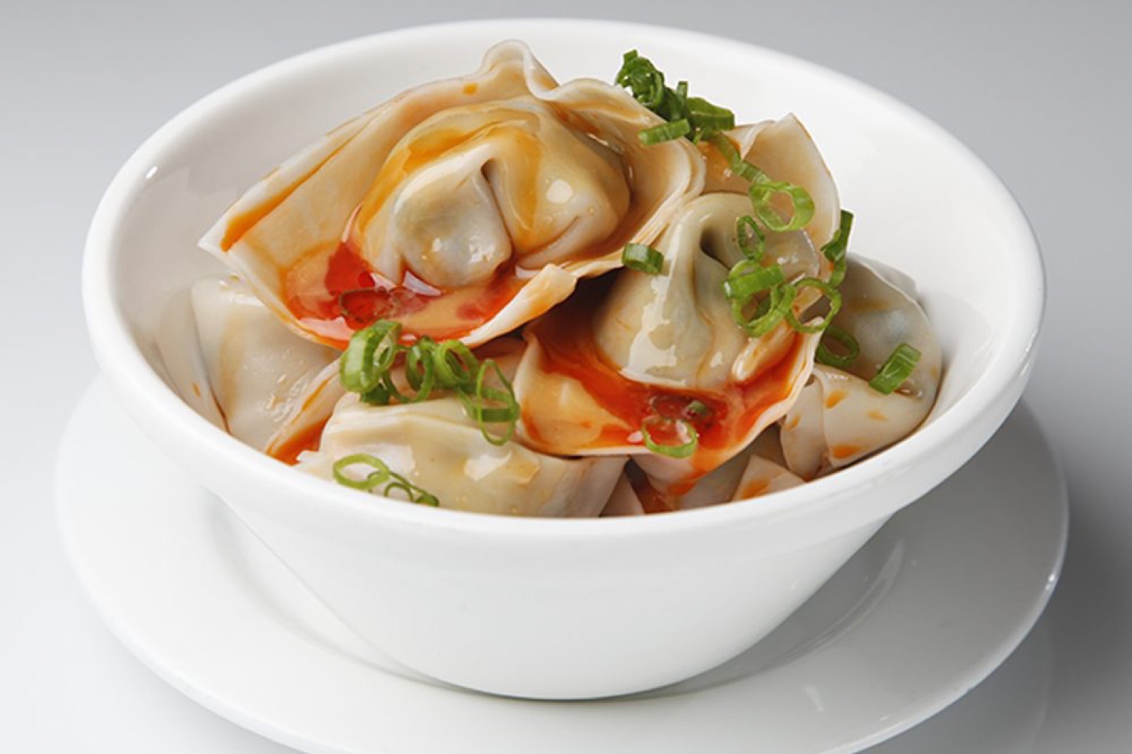 Pork and vegetable wontons in chili oil with peanut sauce